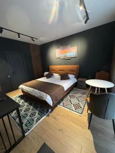 a bedroom with a large bed and a table at Zarechnoe Guest House in Tash-Tyube +3 photos