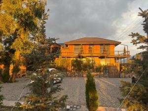 a yellow house with a yard in front of it at Zarechnoe Guest House in Tash-Tyube