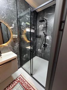 a bathroom with a shower and a sink at Zarechnoe Guest House in Tash-Tyube