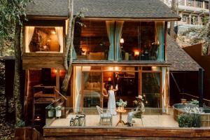 a bride and groom standing on the deck of a house at Morning Star Glamping in Ban Pok Nai