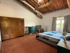 a bedroom with a bed and a cabinet and a window at Villa Gopal Natura Toscana vicino Lucca 7 posti in Capannori