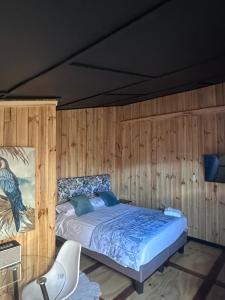 a bedroom with a bed in a wooden wall at Cabaña in Pirque