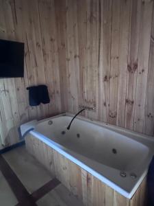 a bath tub in a room with a wooden wall at Cabaña in Pirque +35 photos