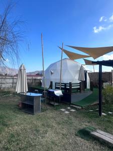 a tent with tables and umbrellas in a yard at Cabaña in Pirque