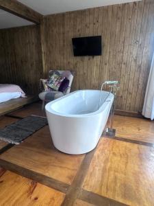 a white bath tub in a room with a tv at Cabaña in Pirque