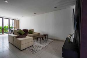 a living room with a couch and a table at Norm Villa Kuta in Kuta