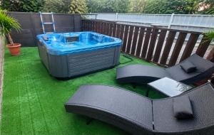 a patio with a hot tub and two chairs at Tó Szálló in Dunapataj
