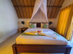 a bedroom with a bed with a canopy and curtains at G Two Cottages in Gili Islands