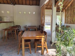 a dining room with a wooden table and chairs at G Two Cottages in Gili Islands