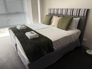 a bedroom with a large bed with towels on it at Med-Accom in Sydney