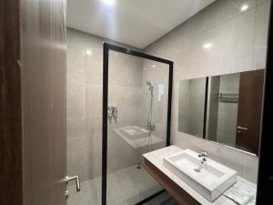 a white bathroom with a sink and a shower at AL-Yasmin in Surabaya