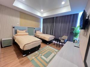a hotel room with two beds and a flat screen tv at AL-Yasmin in Surabaya