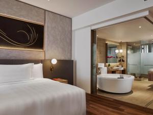 a hotel room with a bed and a bath tub at PARKROYAL Langkawi Resort in Pantai Cenang