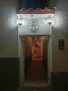 a hallway leading into a building with a sign at Abril Hostel in Mollepata