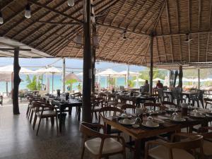 a restaurant with tables and chairs and a view of the ocean at Long Beach Resort Koh Rong in Koh Rong Island