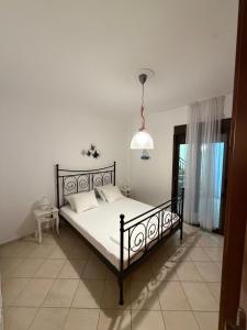 a bedroom with a bed and a pendant light at Aurora Apartment in Afitos