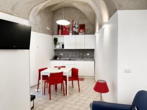 a kitchen with a white table and red chairs at Mana House2 in Maiori