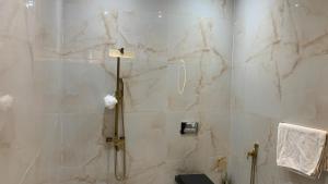 a bathroom with a shower with white marble walls at DAR agafay in Lalla Takerkoust +17 photos
