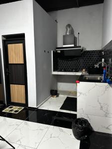 a kitchen with black and white walls and a door at Inap Seri homestay in Jeram