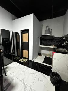 a kitchen with black and white walls and white floors at Inap Seri homestay in Jeram