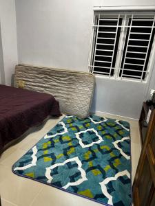 a bedroom with a bed and a rug on the floor at Inap Seri homestay in Jeram