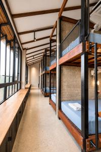 a row of bunk beds in a room with windows at The Laneway Hostel in Xuân Sơn