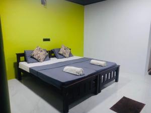 a bed in a room with a green wall at The Wild Lotus YALA in Tissamaharama