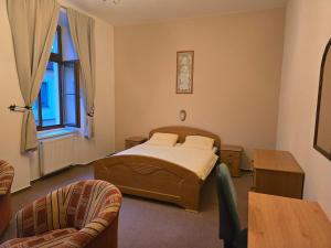 a bedroom with a bed and a table and chairs at Hotel Corso T-X in Rokycany