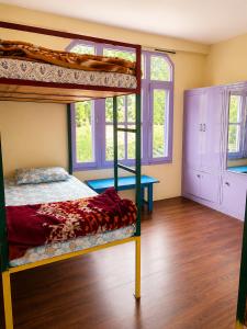 a bedroom with two bunk beds and a desk at Jain Residency in Manāli