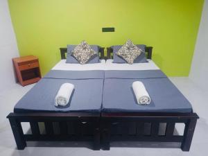 a bedroom with a bed with blue sheets and pillows at The Wild Lotus YALA in Tissamaharama +4 photos