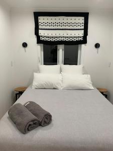 a bed with a blanket and a towel on it at Tiny house in the Treetops in Northland