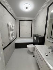 a white bathroom with a toilet and a sink at Best Luxury Residence in Bistriţa +15 photos