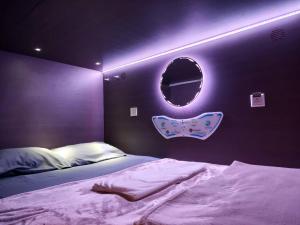 a bedroom with a bed with a purple wall at Q FOX BLACK DIAMOND HOTEL in Kutchan