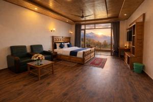 a hotel room with a bed and a balcony with mountains at LN Grand Premium & Luxury Suites, Manali in Manāli