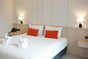 a white bed with two red pillows on it at Aree Tara Ao Nang Krabi in Ao Nang Beach +35 photos