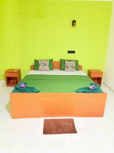a large wooden bed in a room with a green wall at The Wild Lotus YALA in Tissamaharama