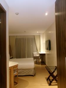 a hotel room with a bed and a desk at Alasra Suites in Ulot