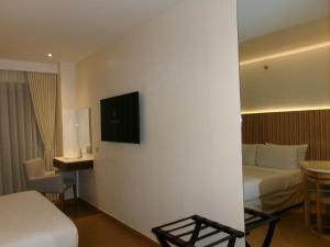 a hotel room with a bed and a television on a wall at Alasra Suites in Ulot
