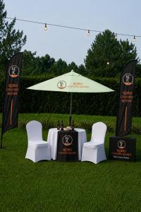 a table and chairs under an umbrella on the grass at koro country resort in Gulu