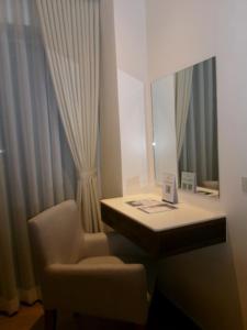 a room with a desk and a chair and a mirror at Alasra Suites in Ulot +2 photos