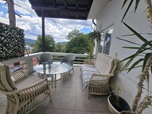 a balcony with a glass table and chairs on a patio at Casa Aurora in Călimăneşti