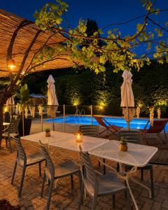 a patio with two tables and chairs and a pool at Hotel Cayrons Vence & St Paul de Vence in Vence