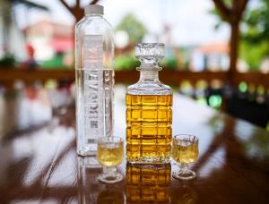 a bottle of whiskey and two glasses on a table at Apartmani Family Nikolic in Popadić