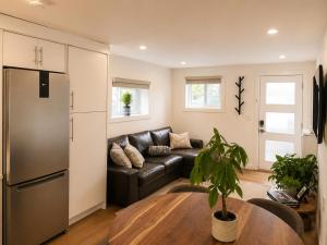 a living room with a black leather couch and a table at Okanagan Valley Beautiful 2 beds 2 bath in Vernon