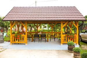 a wooden gazebo with a table and chairs at Apartmani Family Nikolic in Popadić
