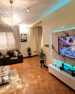 a living room with a couch and a flat screen tv at Deluxe unique homes kampala in Kampala