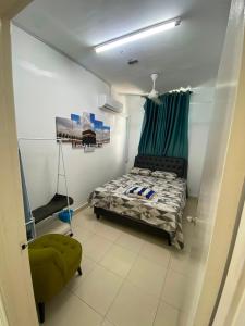 a bedroom with a bed and a green chair at DRIFF Homestay 3bedroom with aircond 50m to Night Market Wakaf Che Yeh in Kota Bharu