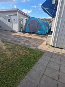 ein blaues Zelt neben einem Gebäude in der Unterkunft Zingo in Borgholm