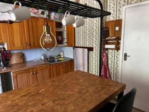 a kitchen with wooden cabinets and a wooden table at Cosy house with forest view in Pyussi