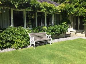 a bench sitting in the grass in front of a house at Sea Dew B&B in Tullamore